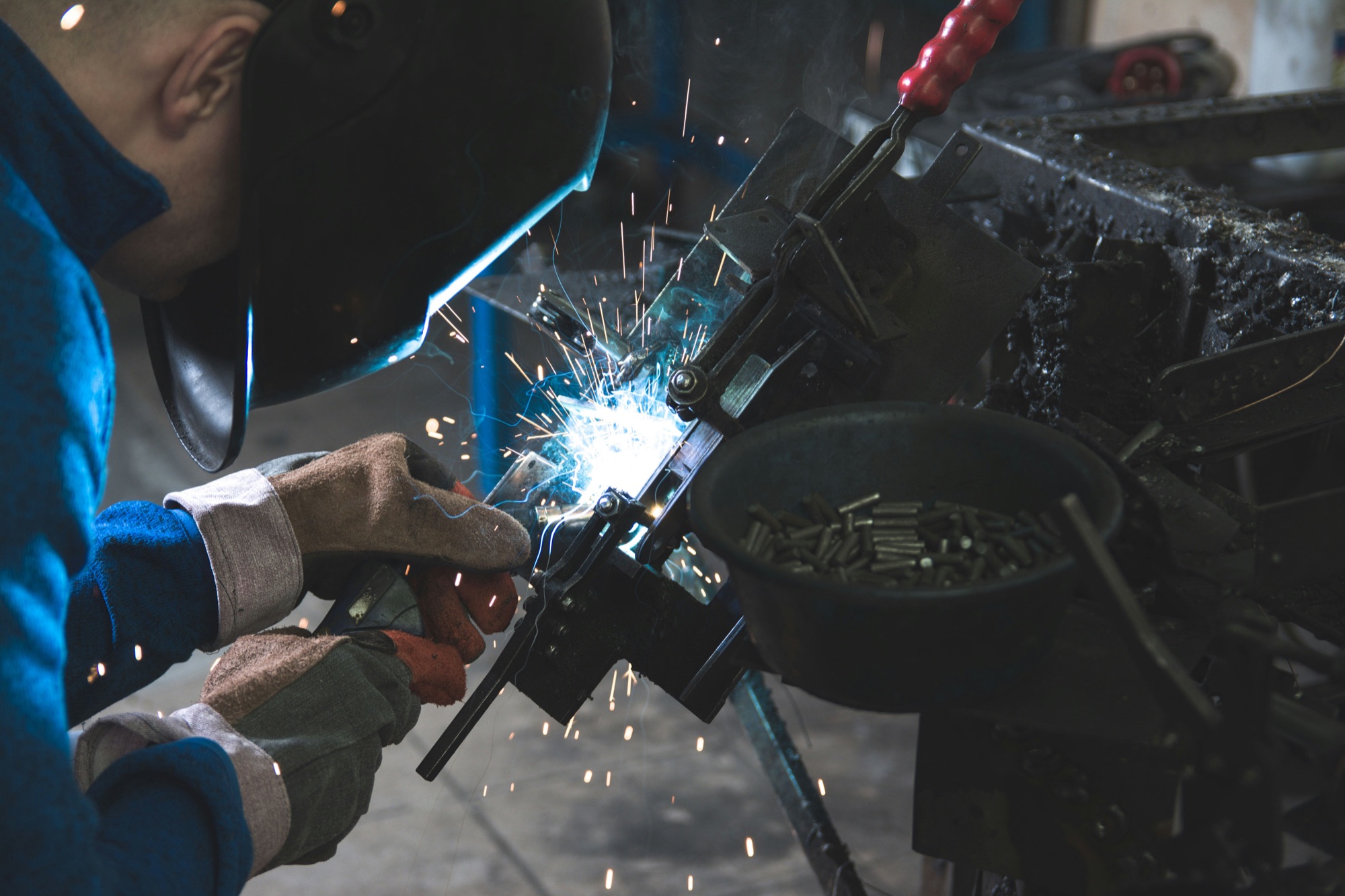 Close-up of a welder working on a black metal piece